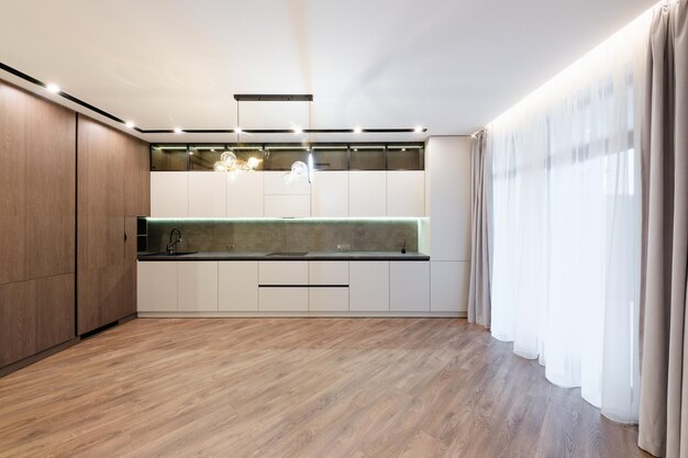 Interior design of a large studio kitchen with light and dark\
facades