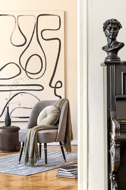 Дизайн интерьера гостиной со стильным серым креслом, абстрактными картинами, цветами в вазе, подушкой, пледом, черным пианино и элегантными личными аксессуарами. Бежевая концепция Современная домашняя постановка. Шаблон