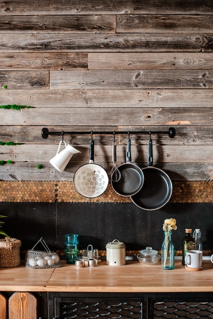 Interior and design of modern home kitchen in rustic style. In the background is a wall of wooden planks.