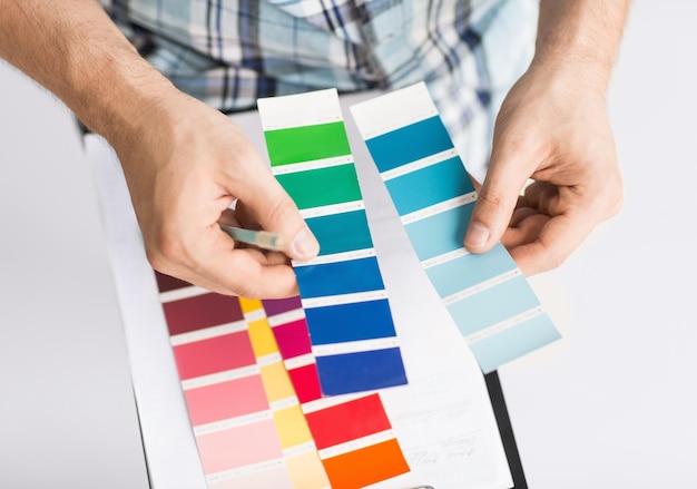 interior design and renovation concept - man with color samples for selection