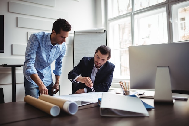 Interior designer working on blueprint with coworker