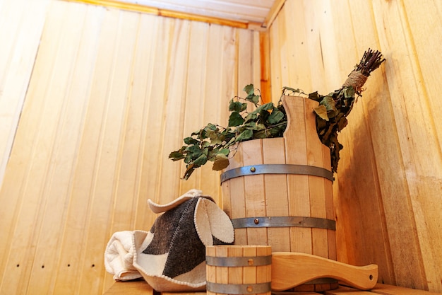 인테리어 세부 사항 전통적인 사우나 액세서리가있는 핀란드 식 사우나 한증 실. 분지 자작 나무 빗자루 국자 펠트 모자 수건
