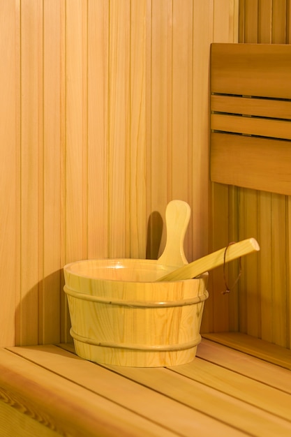 インテリアの詳細伝統的なサウナアクセサリーの洗面器スクープを備えたフィンランド式サウナスチームルーム。