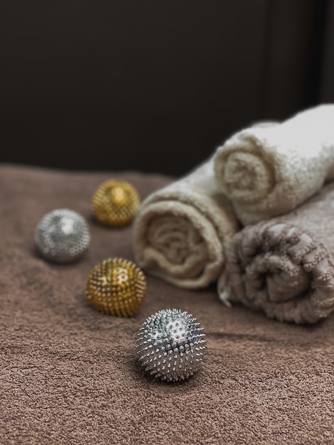 Interior elements for comfort in a beauty studio. a pleasant\
atmosphere in the massage room. spa background. beautifully folded\
towels, gold and silver massage balls