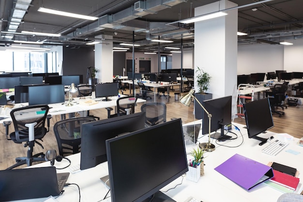 Интерьер пустого современного офиса со столами и компьютерами. современный офис креативного дизайнерского бизнеса.