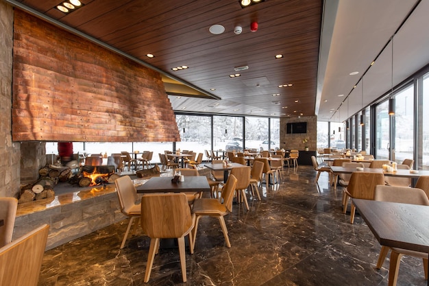 interior of an empty mountain restaurant with large fireplace in the middle