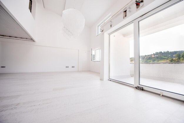 Photo interior of empty stylish modern open space two level apartment with white walls and large round chandelier in the middle ready to move in