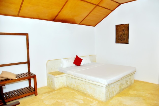 Interior of a hotel bedroom white walls and wooden bed