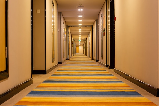 Photo interior of the hotel long corridor with a striped walkway.