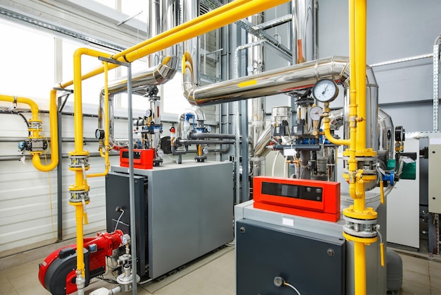 The interior of an industrial boiler house with a multitude of pipes boilers and sensors