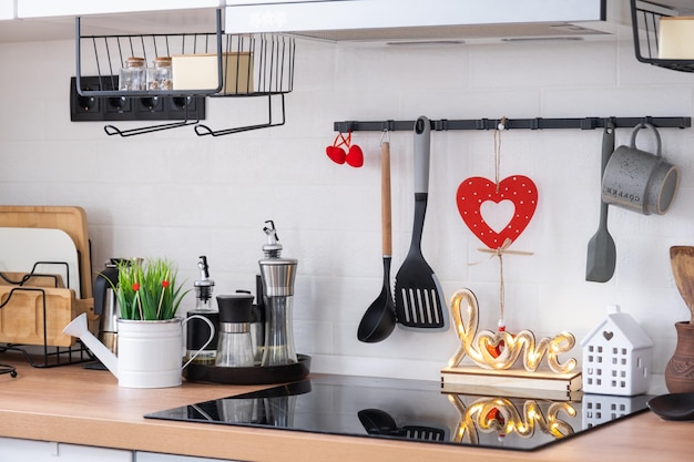 The interior of the kitchen in the house is decorated with red hearts for Valentine's Day Decor on the table stove utensils festive mood in a family nest