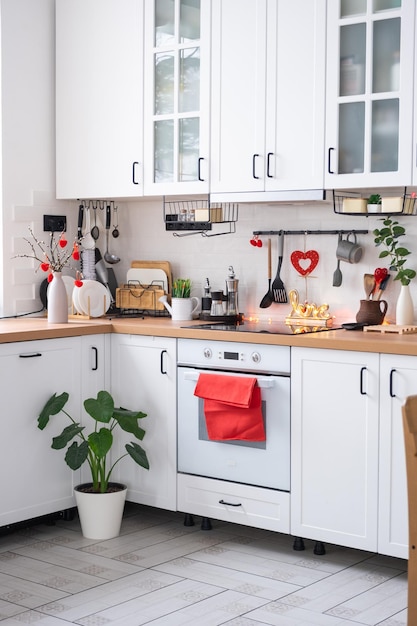 Photo the interior of the kitchen in the house is decorated with red hearts for valentines day decor on the table stove utensils festive mood in a family nest