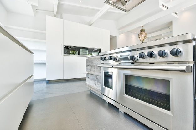 Interno della cucina con moderne stufe in acciaio inox in appartamento progettato in stile minimal