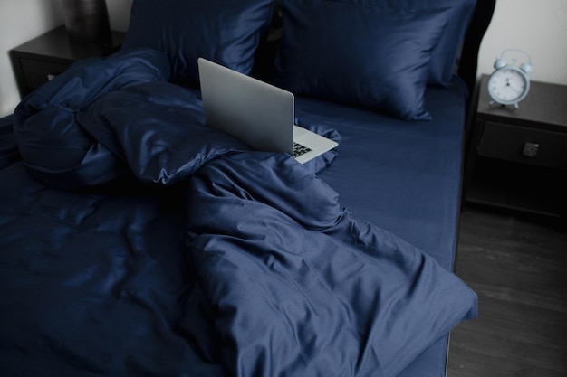 커피 책과 노트북이 있는 아침 침대가 있는 인테리어 및 레저 컨셉의 아늑한 침실