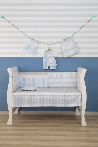 Interior of light cozy baby room with crib and bedding