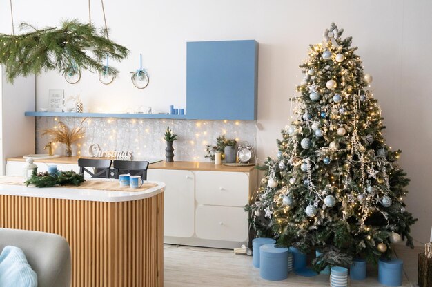 Cucina interna grigio chiaro e decorazioni natalizie rosse. preparare il pranzo a casa sul concetto di cucina. focus sull'albero