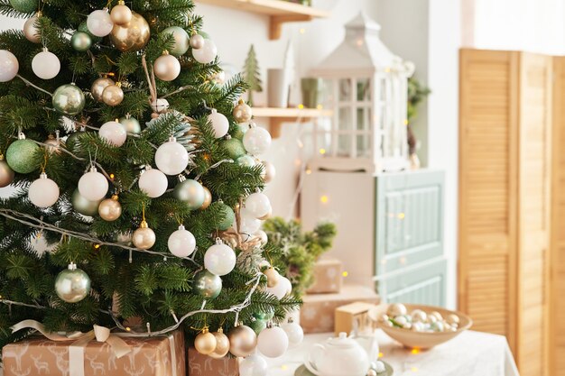 Interior light kitchen with christmas decor and tree. Turquoise-colored kitchen in classic style