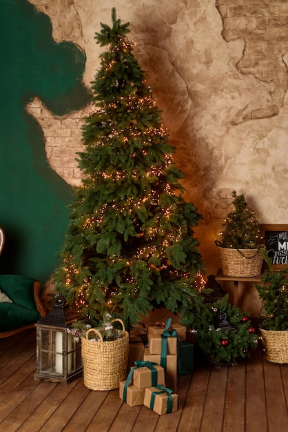 The interior of the living room in the Christmas style with a large fir-tree and Сhristmas gifts