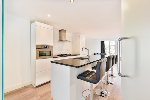 The interior of a magnificent kitchen with a black countertop and a white kitchen set