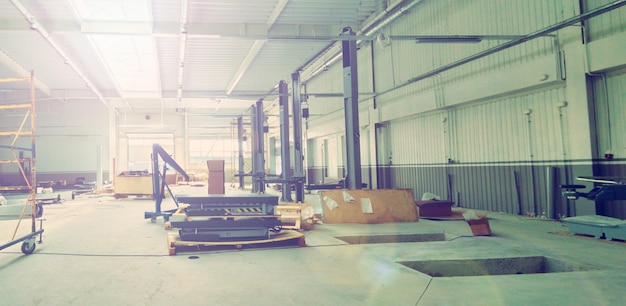 The interior of a modern automotive dealership maintenance\
garage with hydraulic lifts exhaust ventilation system tool storage\
and energy efficient lighting