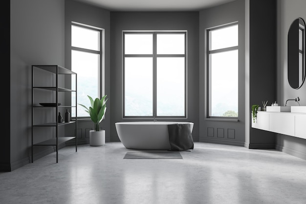 Interior of modern bathroom with gray walls, concrete floor, white bathtub with gray towel on it, white double sink and gray shelves. 3d rendering