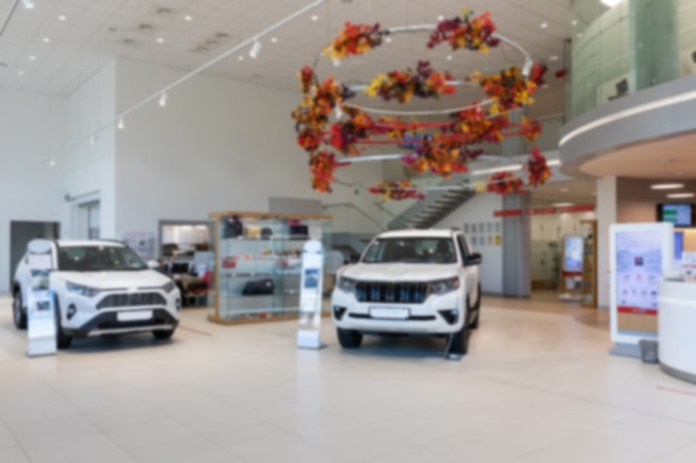 Foto interno di una moderna concessionaria di auto con foto di showroom premium suv bianchi con sfocatura