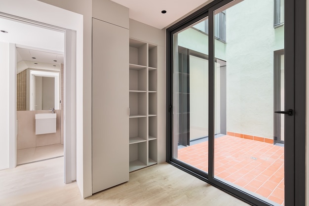 Interior of modern empty room in refurbished apartment with big black frame of windows wardrobe and ...