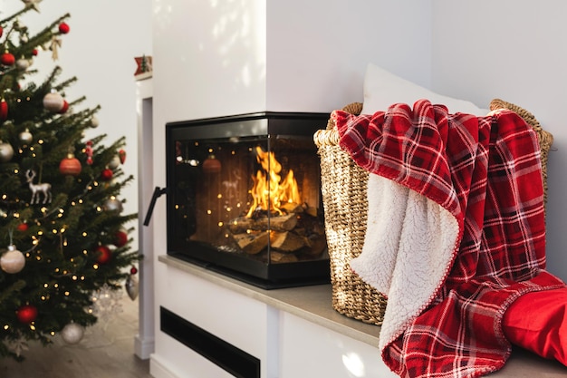 Interior of a modern living room with a burning fireplace adorned with a Christmas decorations