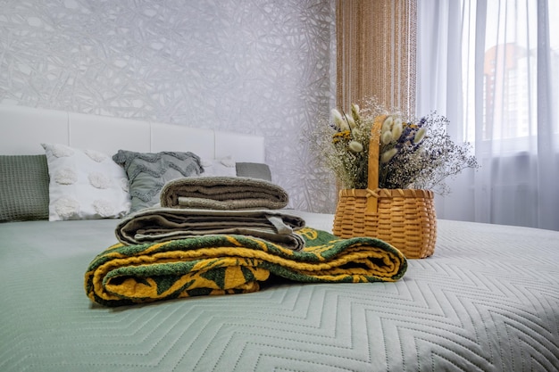 Interior of the modern luxure bedroom in studio apartments in light color style with pillows and towels