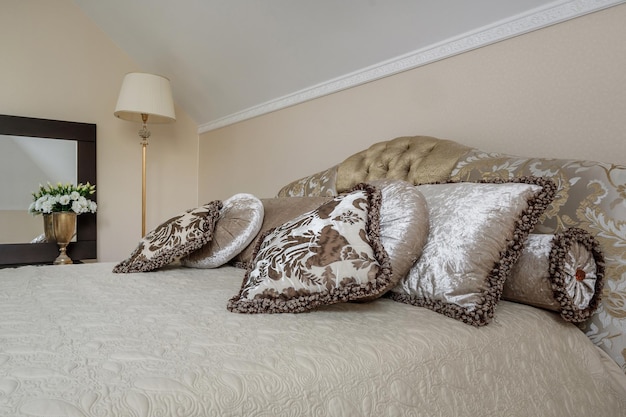 Interior of the modern luxure bedroom with pillows on the bed in studio apartments in light color style