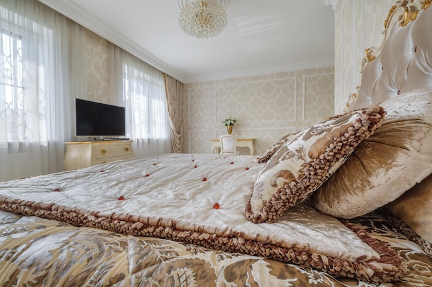 Interior of the modern luxure bedroom with pillows on the bed in studio apartments in light color style