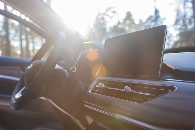 Interior of modern luxury car in sunshine monitor airduct and steering wheel on premium car side