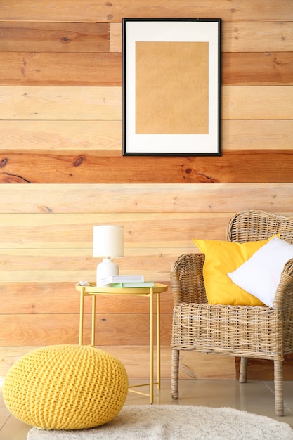 Интерьер современной комнаты с удобным креслом и столом у деревянной стены