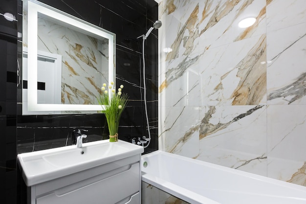 Interior of a modern small bathroom with white and black marble tiles