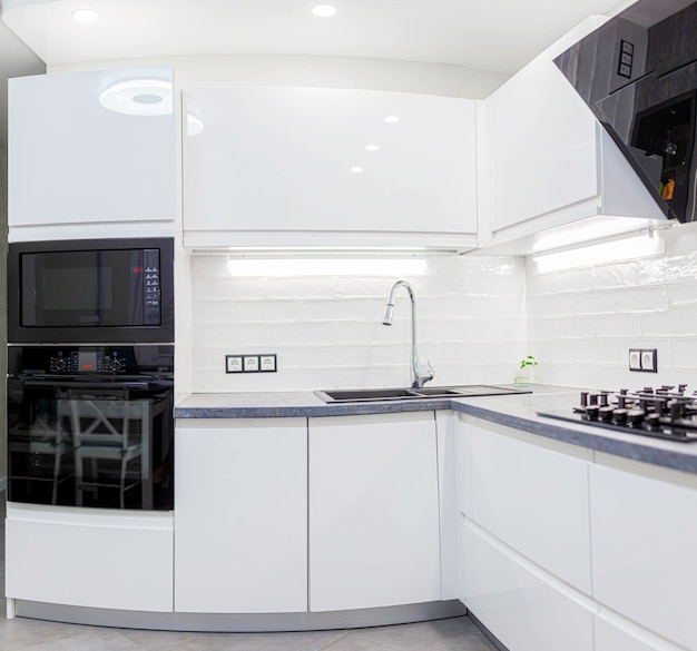Interno di una moderna piccola cucina con piastrelle bianche ed elettrodomestici