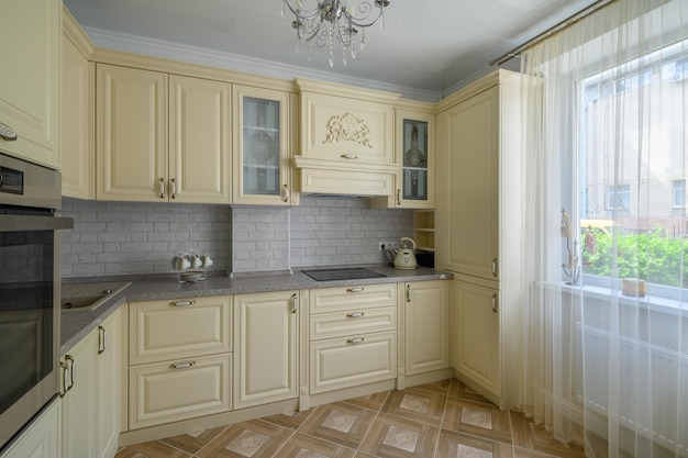 Interior of modern trendy cream colored kitchen