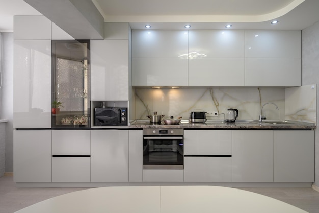 Interior of modern trendy white kitchen front view