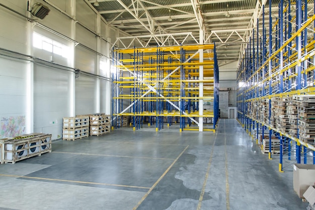 Interior of a modern warehouse storage of retail shop with\
pallet truck near shelves rows of steel shelves and racks