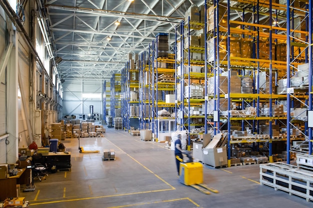 Interior of a modern warehouse storage of retail shop with\
pallet truck near shelves