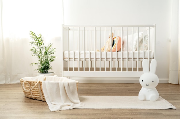 Photo interior of nursery room with baby crib and cradle