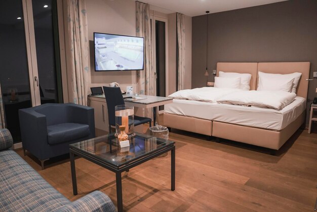 Фото Интерьер освещенной комнаты в роскошном отеле с кроватью и телевизором