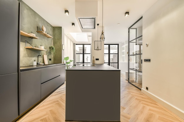 The interior of an open kitchen with a bar in gray tones in a modern apartment