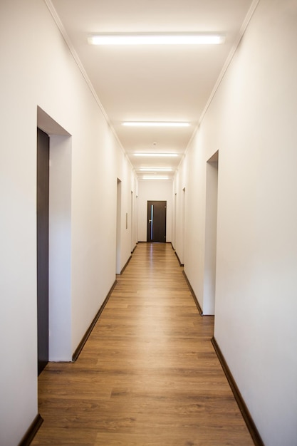 Interior perspective of empty corridor with many doors