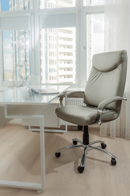 Interior photo of office leather chair behind white working table