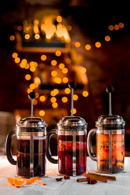 Foto interno di un ristorante decorato per natale con luci dorate bokeh di ghirlanda, stampe francesi con diversi tipi di tè