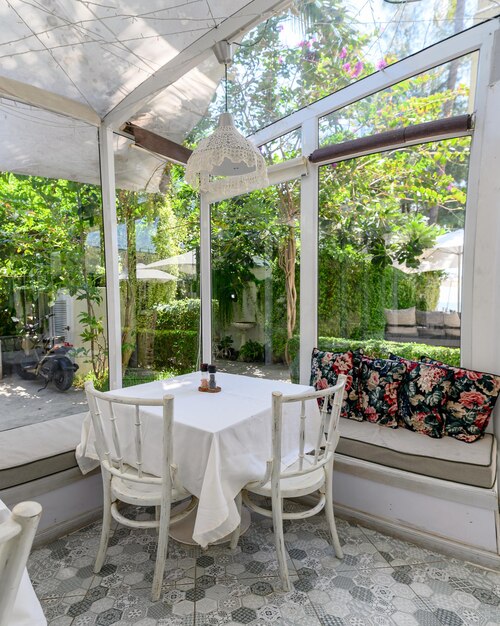 Foto interno di un ristorante con tavolo da pranzo e sedie in giardino