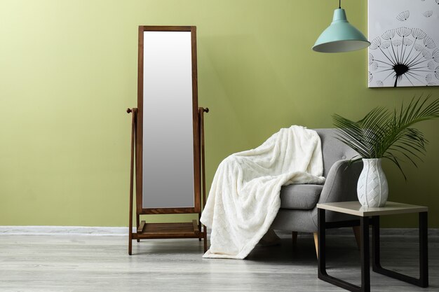 Interior of room with armchair, table and mirror