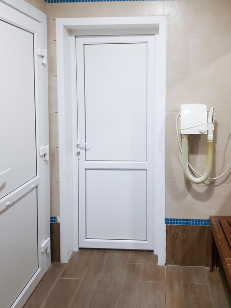 The interior of the shower room of the pool or spa center with a hairdryer and a door closeup