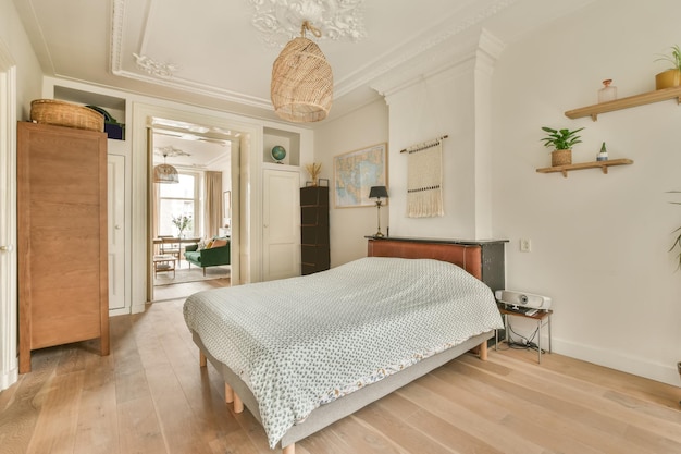 The interior of a spacious bedroom with a large bed and a wooden wardrobe next to it