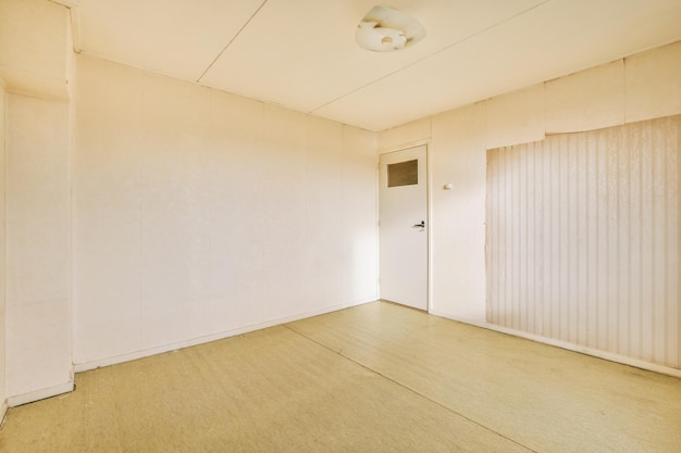 Интерьер просторной пустой комнаты со светлыми обоями на стенах в уютном доме